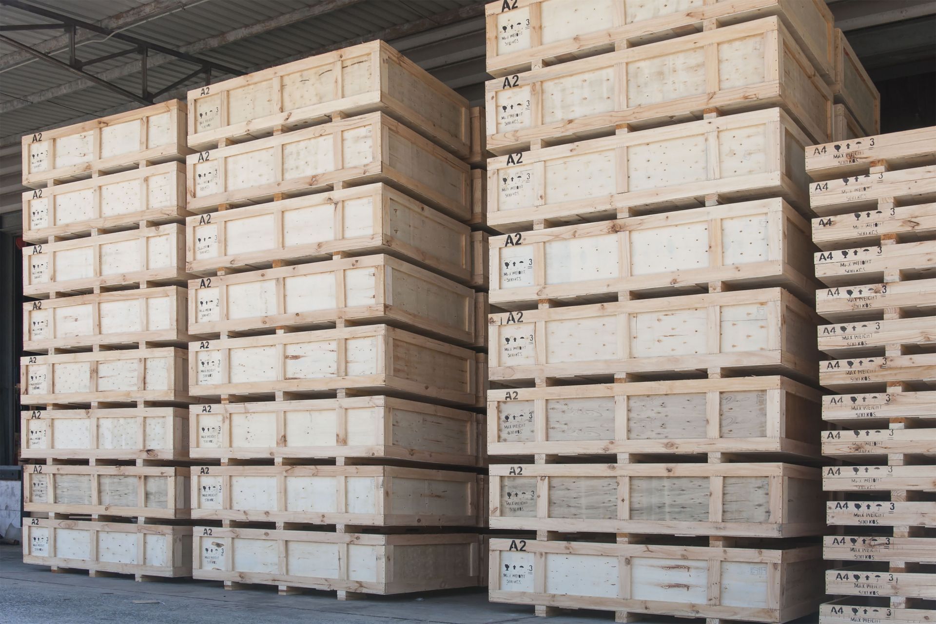 Stacks of wooden crates in a warehouse, likely for shipping or storage.