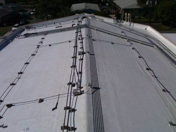 White roof with dark conduits and connectors running along it.
