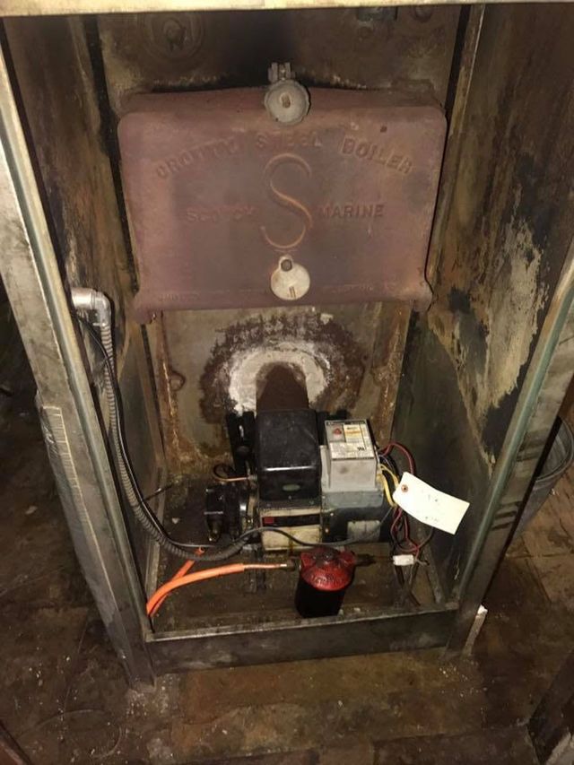 Small industrial machine with wires and a label inside a worn metal enclosure.