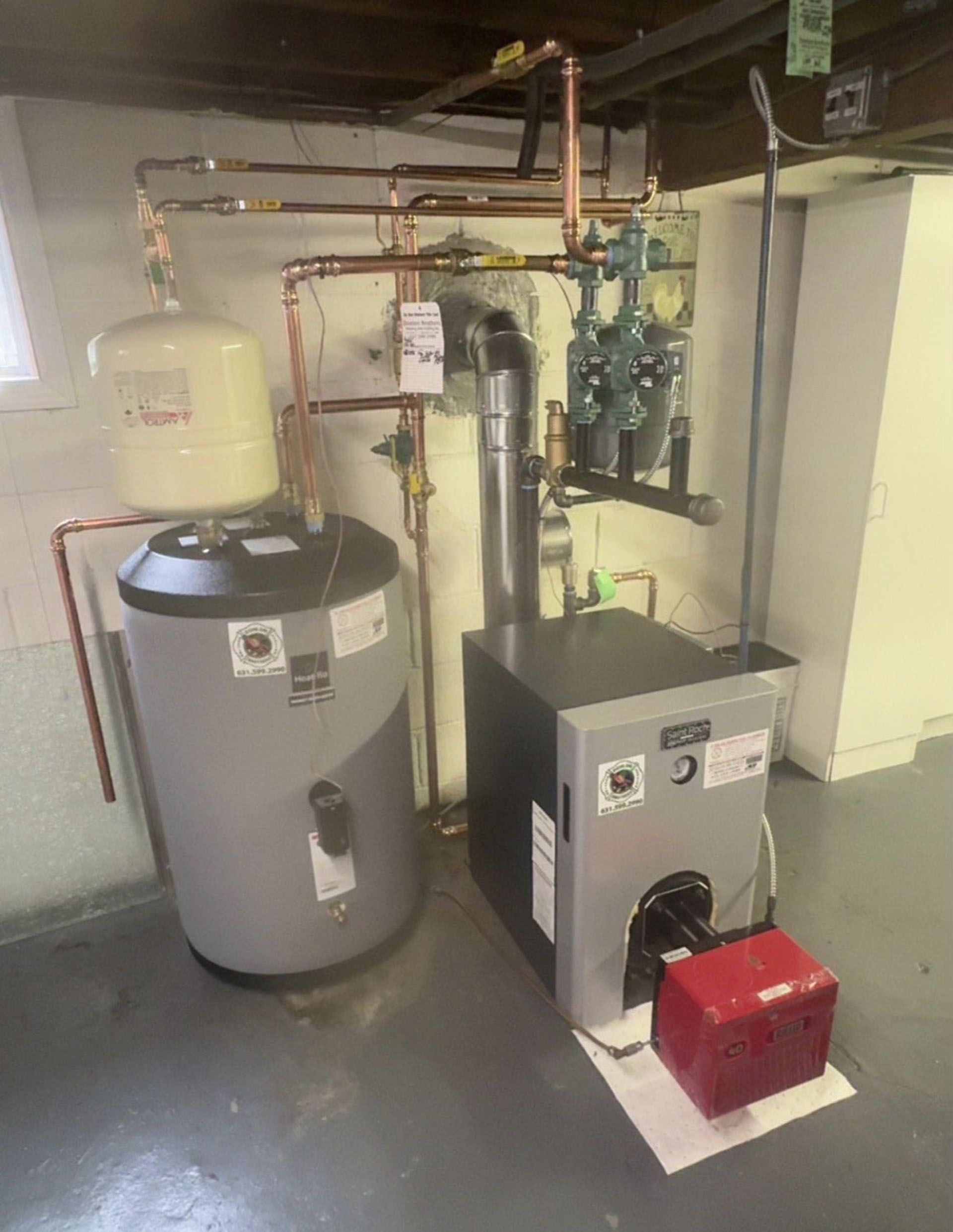 Basement utility room with water heater, furnace, and exposed pipes.