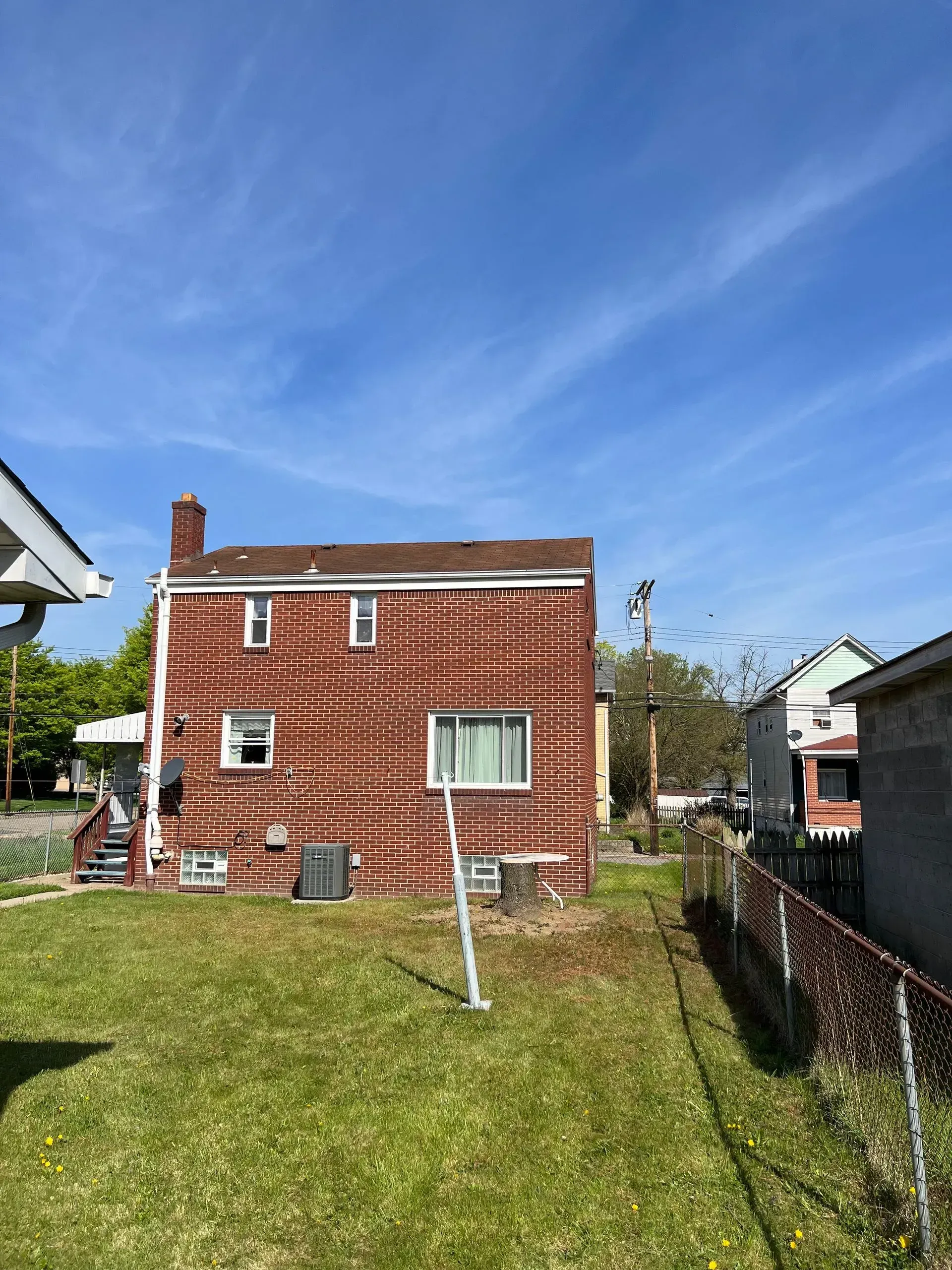 Red brick building, grass yard, blue sky.