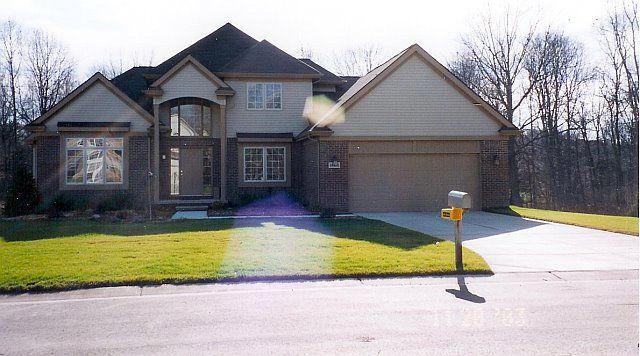 Suburban house with a two-car garage and front lawn on a sunny day