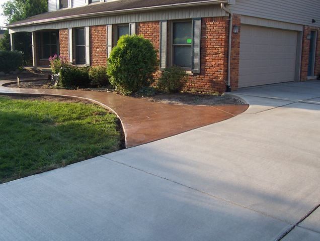 Brick house with a curved concrete driveway and front lawn