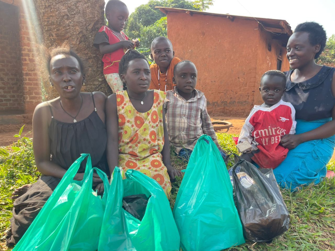 Group of people with bags of supplies in front of a building.