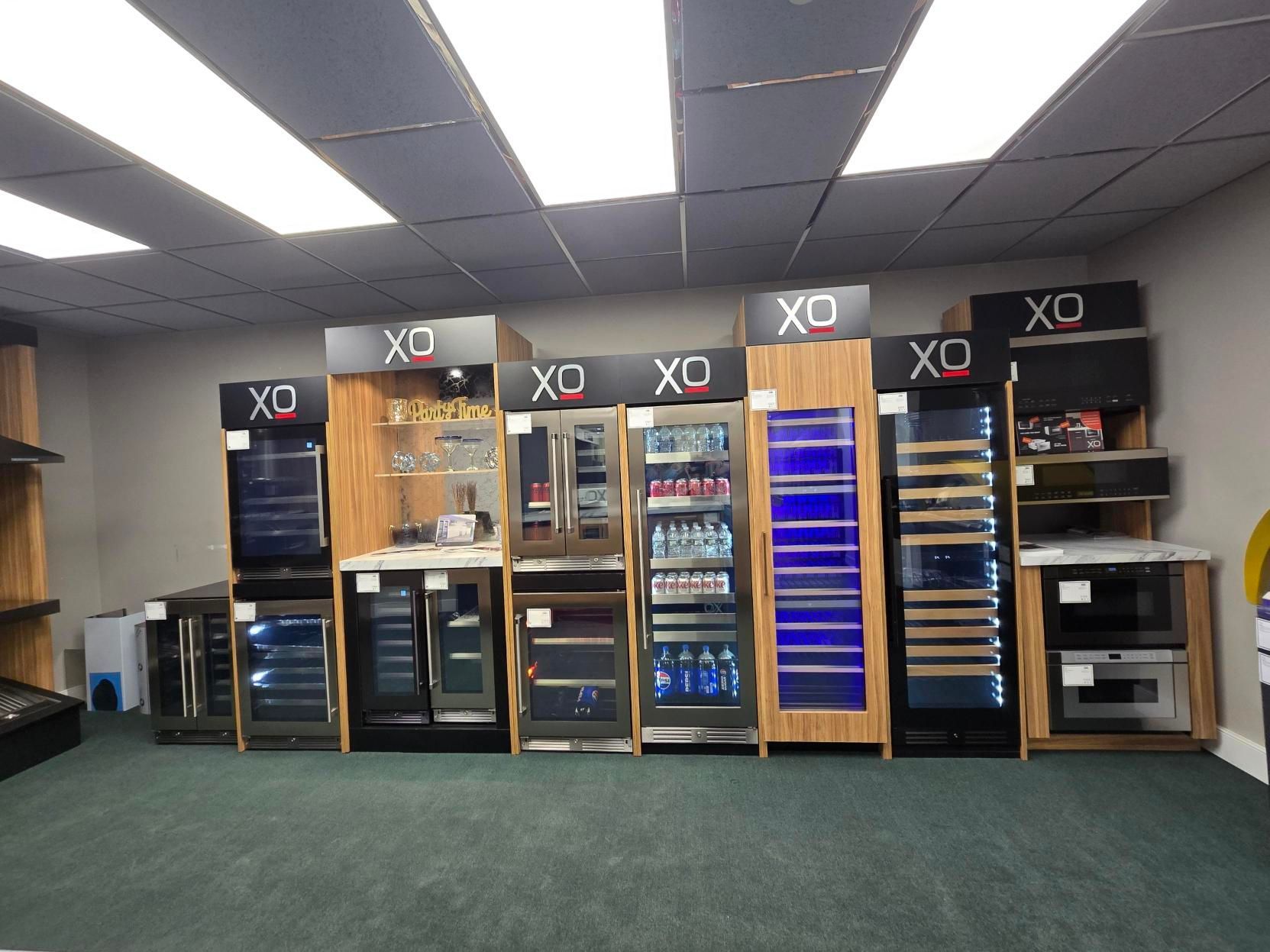 Display of various XO brand wine and beverage refrigerators in a showroom.