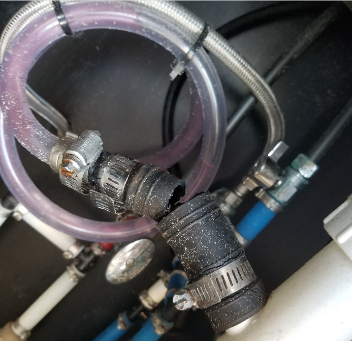 Broken water hose connection with clamps and multiple tubes.