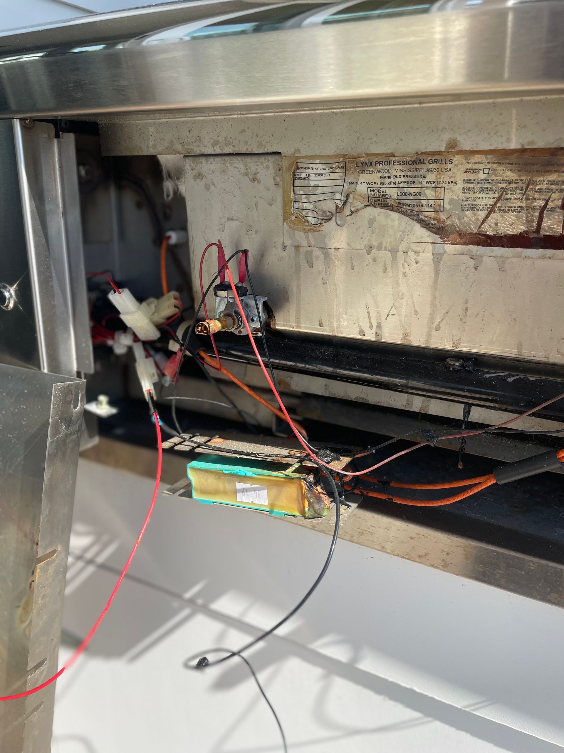 Inside of a metal appliance, exposed wiring and electrical components are visible.