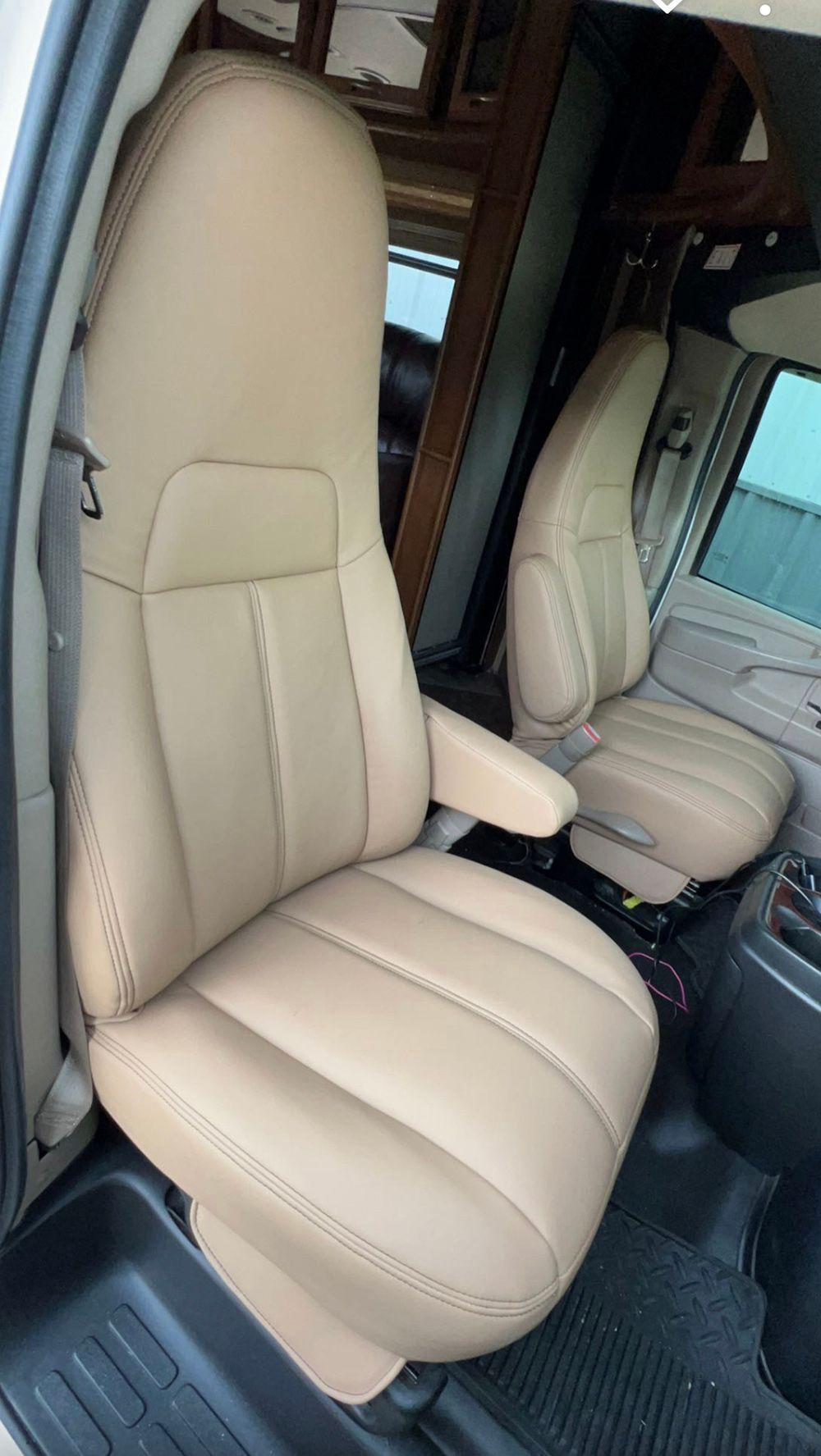 Tan leather vehicle seats inside a van.