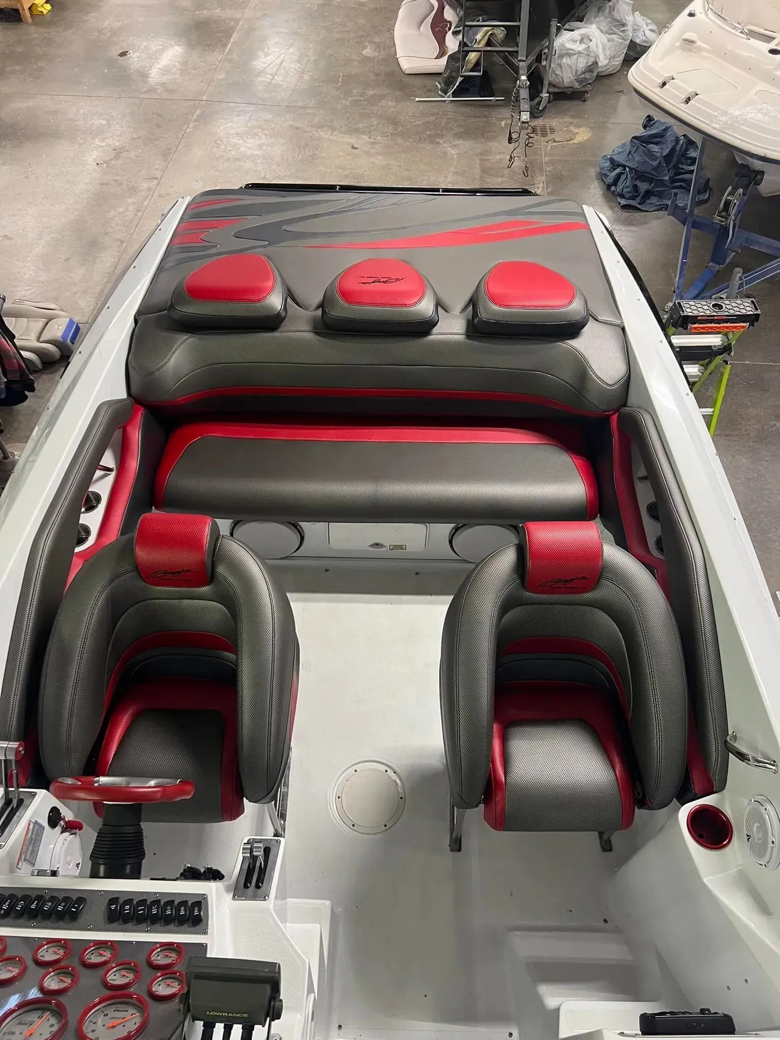 Interior of a performance boat with red and black seats, dashboard and accents.