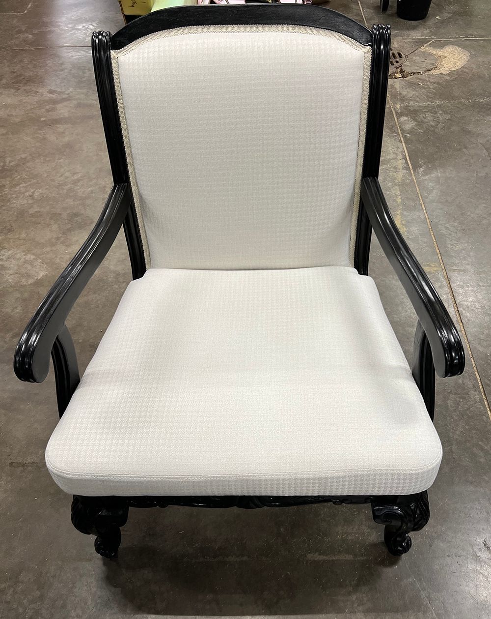 Black framed armchair with white upholstered seat and back.