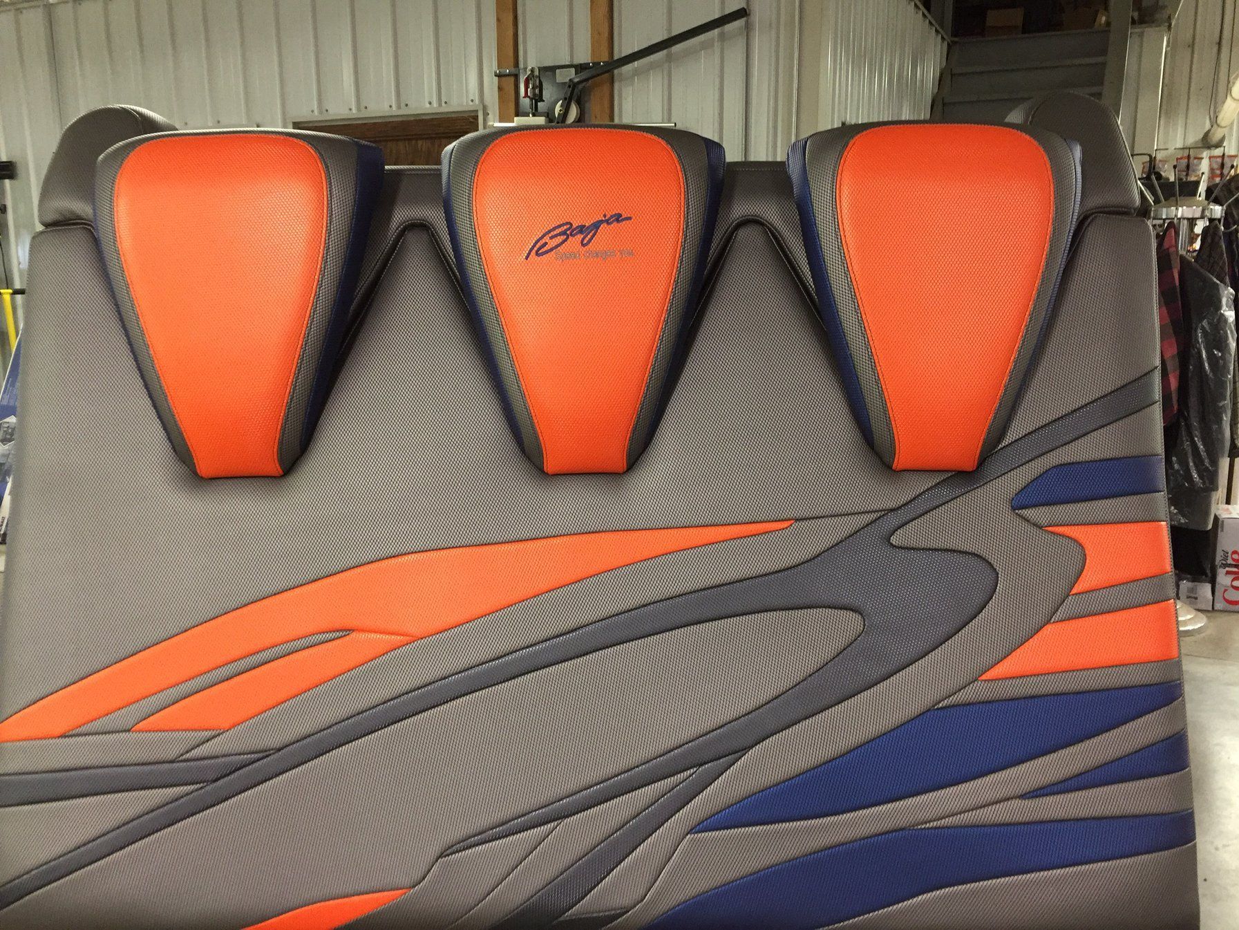 Back rest with three orange headrests and gray, orange, and blue patterned details.