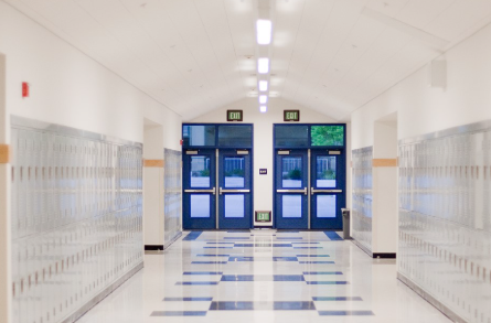 An empty school hallway with blue doors and lockers