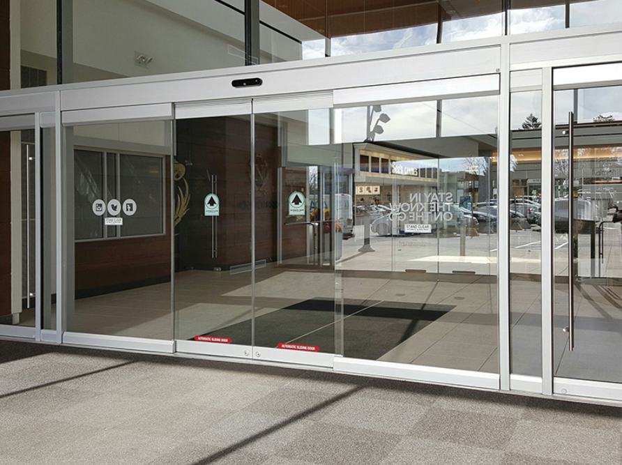 A large glass door with a reflection of a building in it
