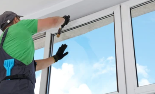A man is cleaning a window with a brush.