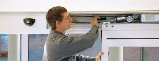 A man is working on a sliding glass door.