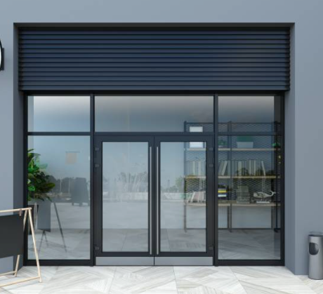 A store front with a large glass door and a black shutter.