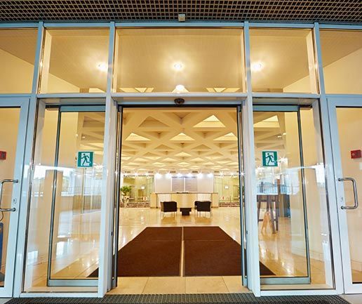 A large glass door with a sign that says ' emergency exit ' on it