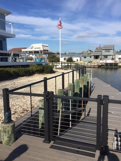 Dock with black metal railing, wooden posts, and a flagpole with American flag.