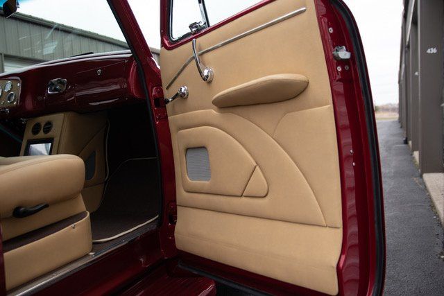 Inside car door, tan and red, with speaker and armrest.
