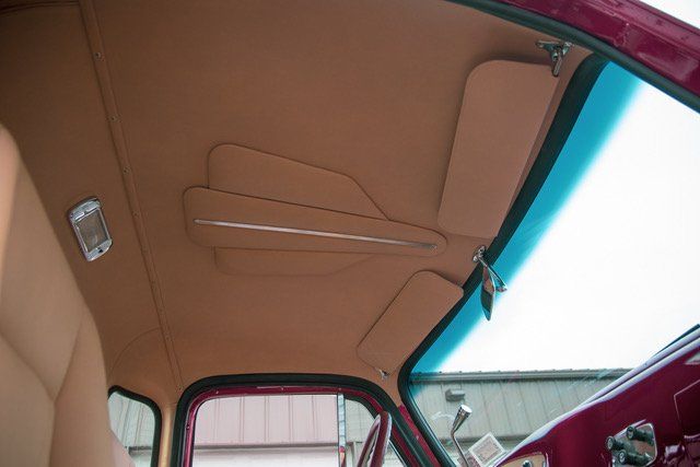 Tan car interior with headliner, visors, and side window.