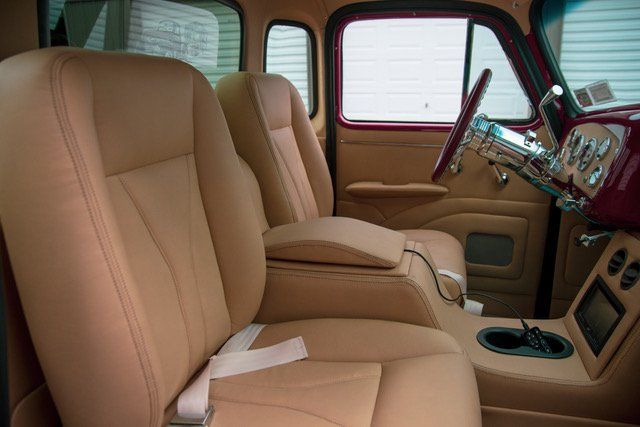 Tan leather car interior with custom center console and two front seats.
