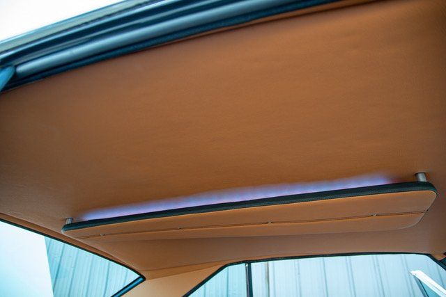 Tan car interior, showing a headliner and visor.