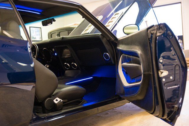 Blue classic car interior with blue neon lighting. Door open.