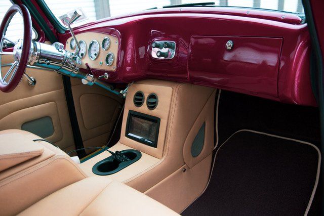 Tan and burgundy custom car interior: dashboard, center console, steering wheel, seats.