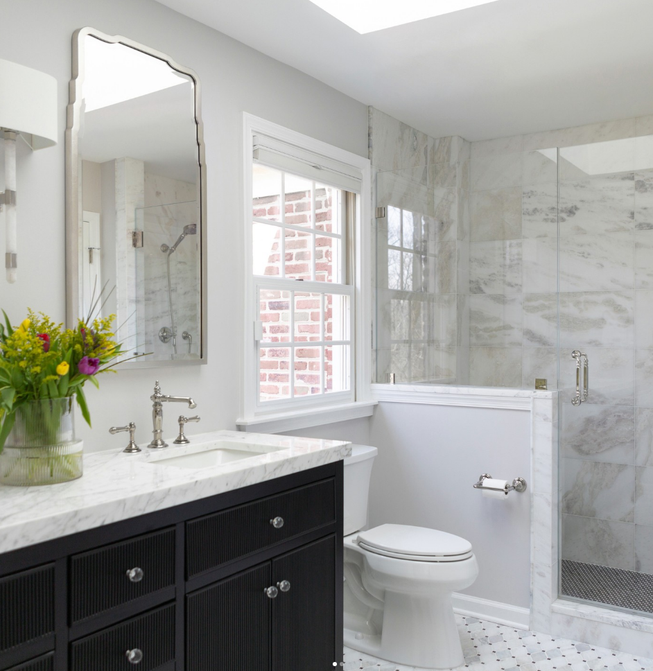 A bathroom with a toilet a sink and a mirror