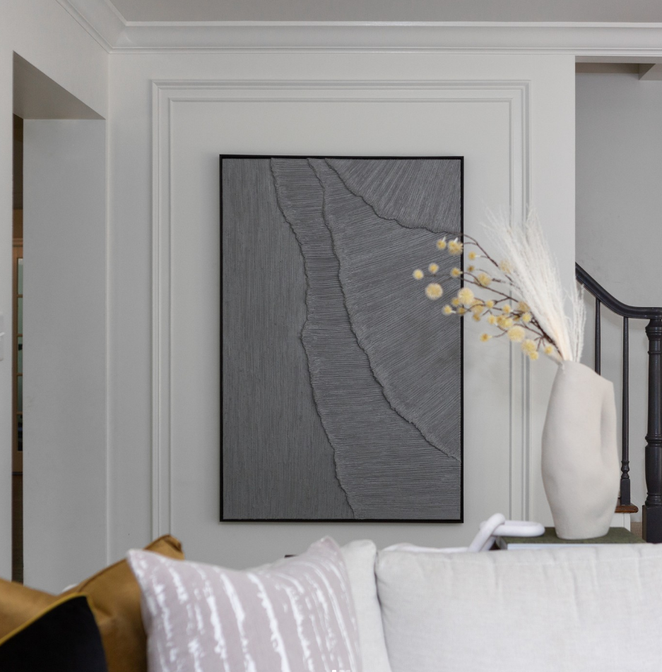 A living room with a couch and a painting on the wall