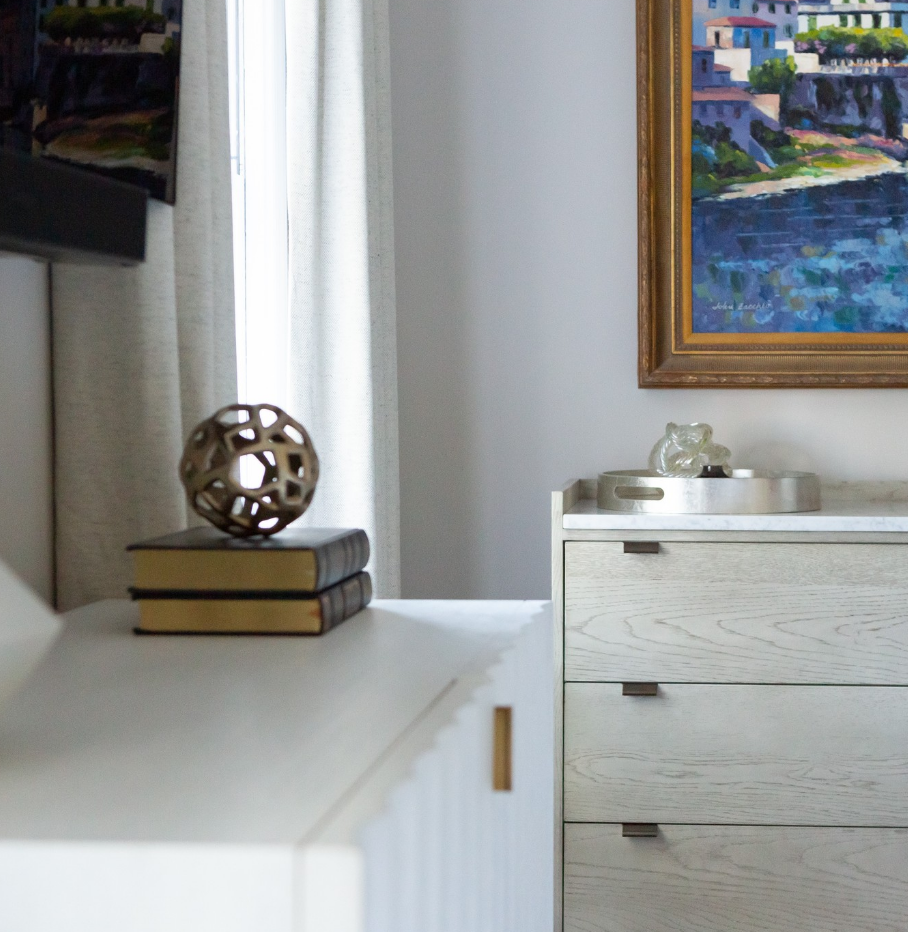 A room with a dresser and a painting on the wall