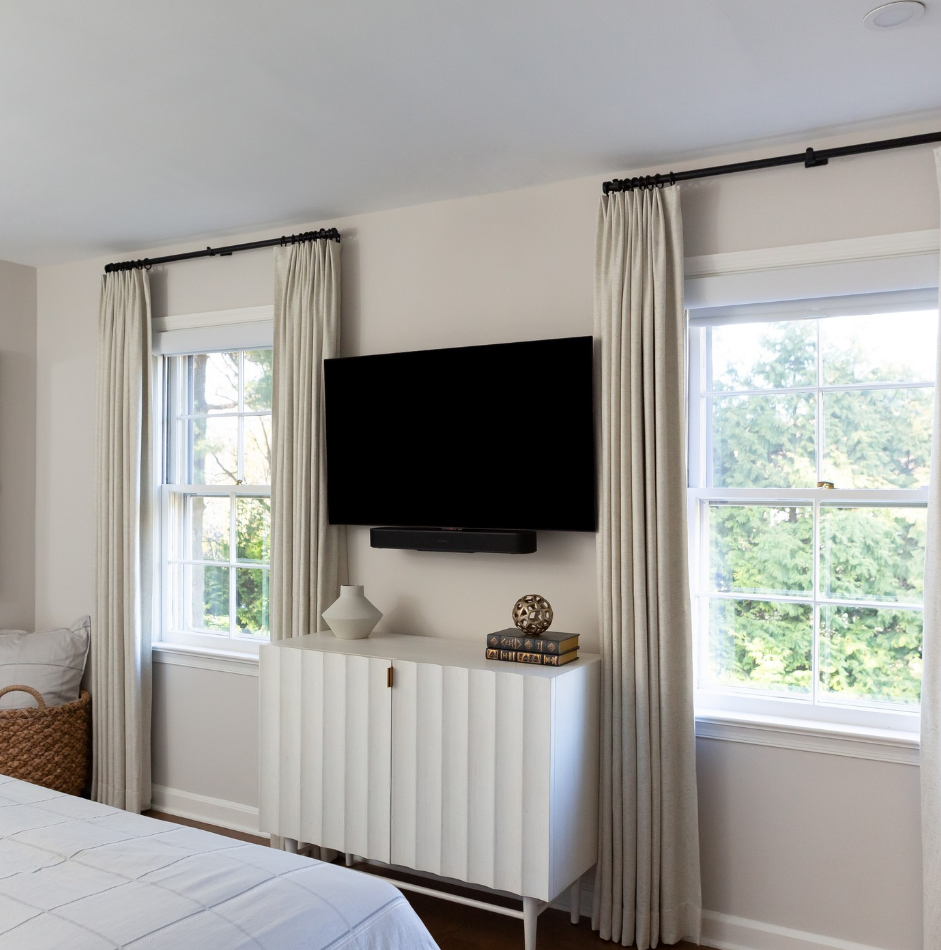 A bedroom with a large flat screen tv on the wall