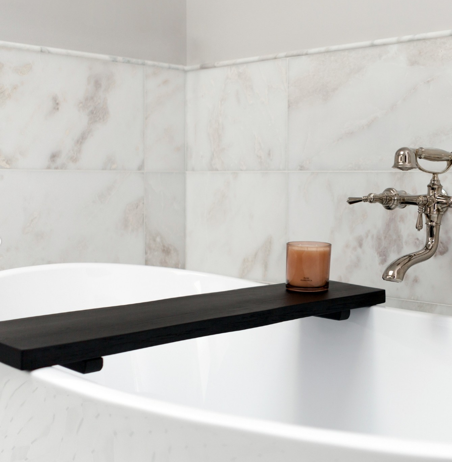 A bathtub with a candle on the side of it