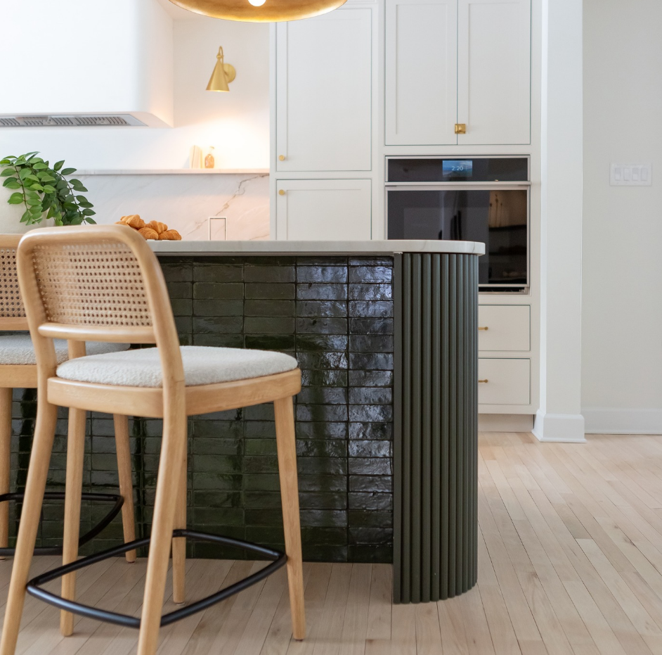 A kitchen with two stools and a large island