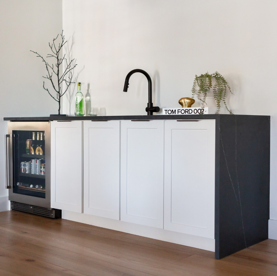 A kitchen with white cabinets and a stainless steel refrigerator