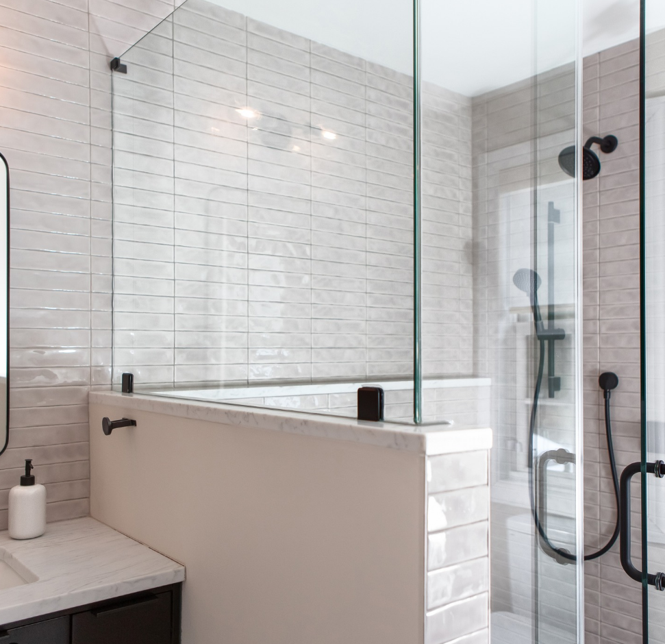 A bathroom with a tub , sink , mirror and shower.