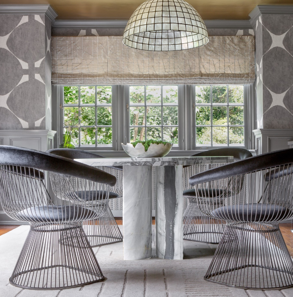 A dining room with a table and chairs and a lamp hanging from the ceiling