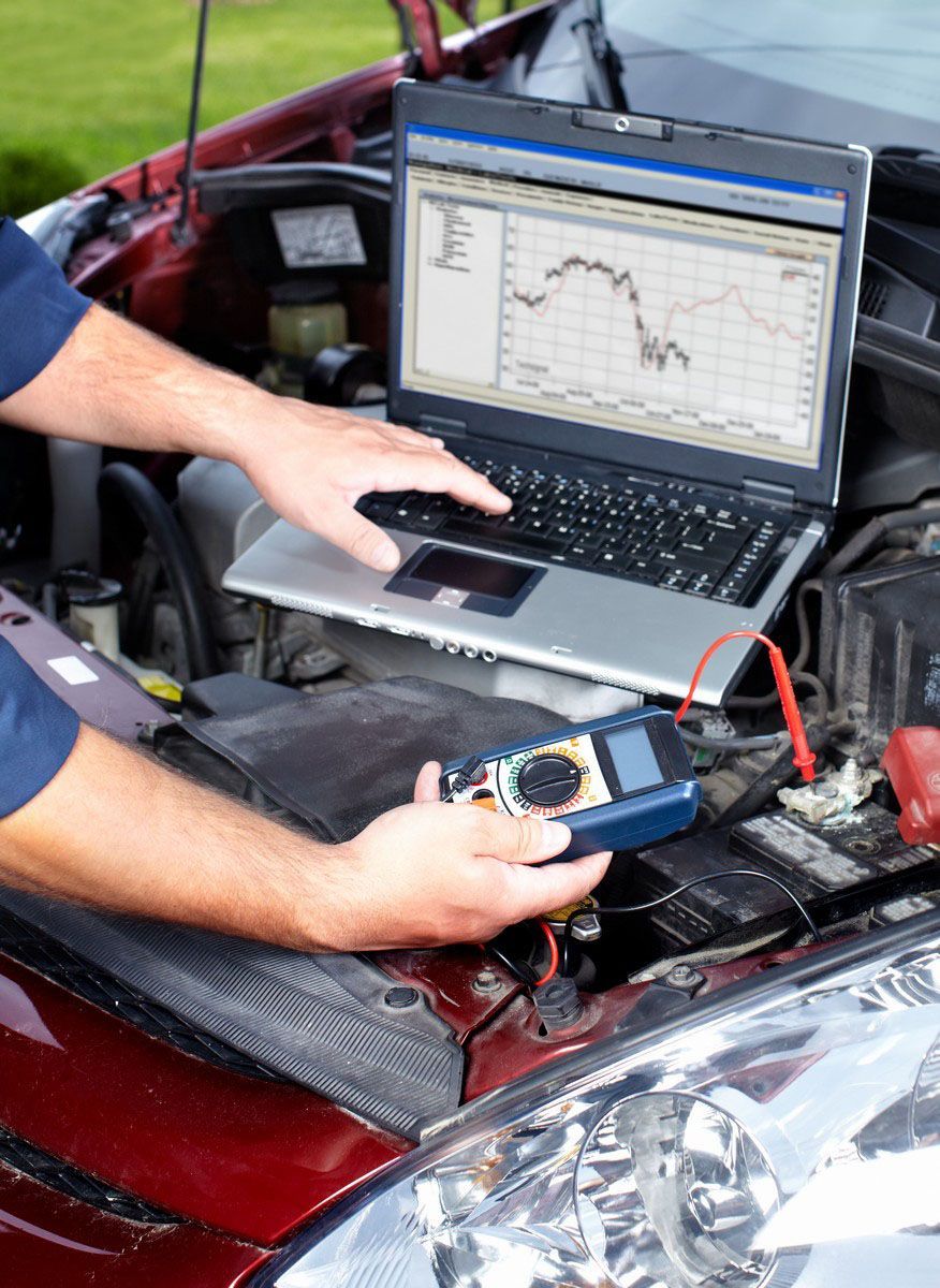 Mechanic checking the engine using a laptop
