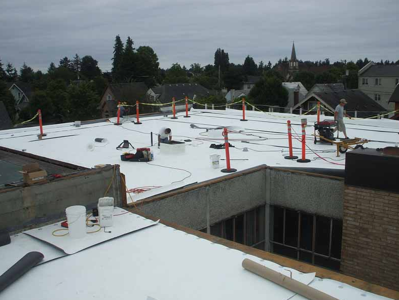 A white roof is being installed on a building
