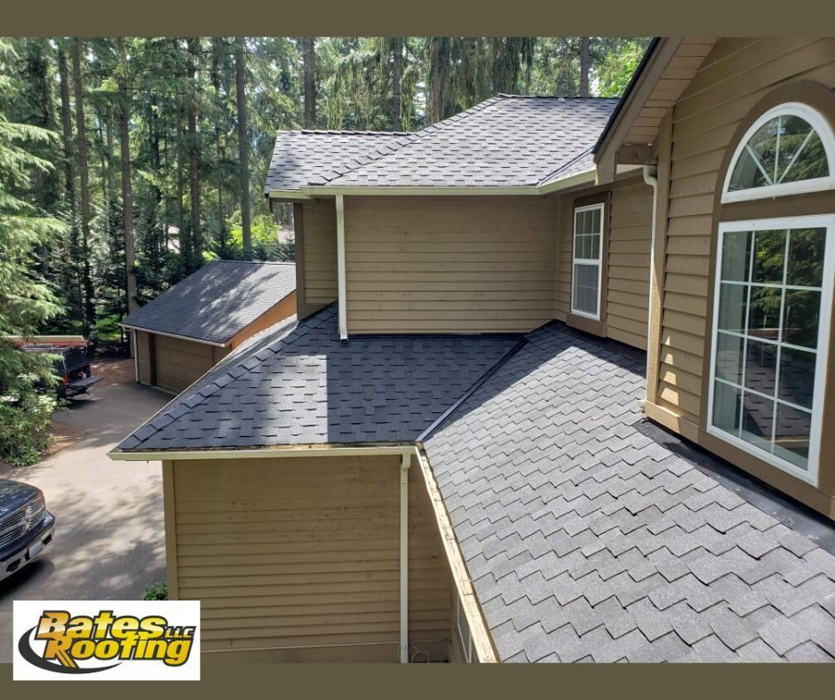 A house with a black roof and a car parked in front of it.