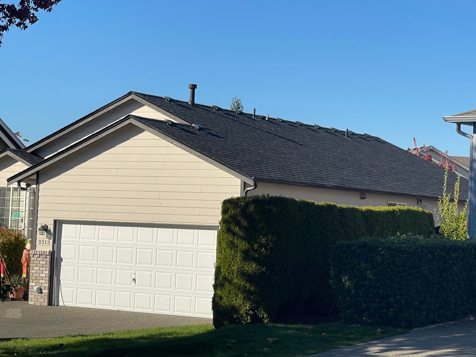 A house with a black roof and a white garage door