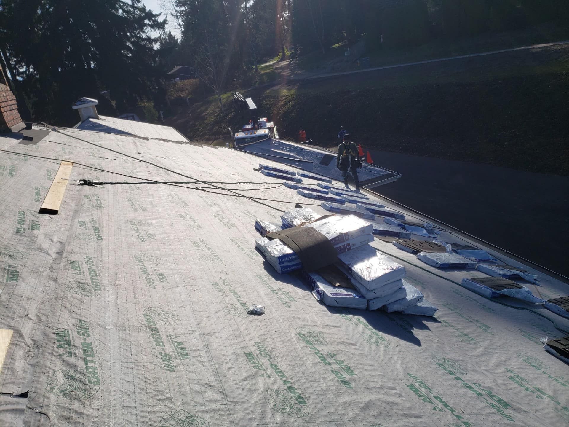 A man is standing on a roof with a bunch of boxes on it.