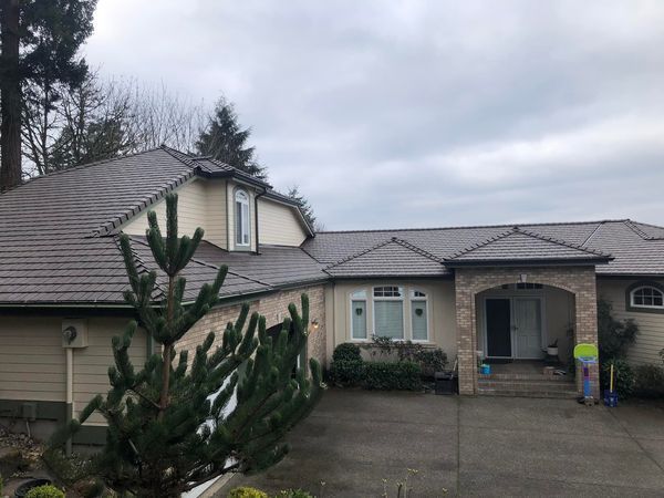 A large house with a slate roof and a driveway.