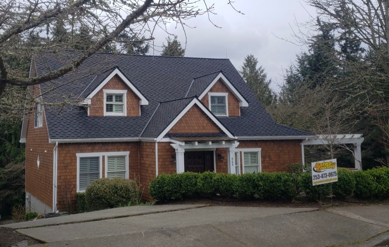 A large brick house with a blue roof is for sale