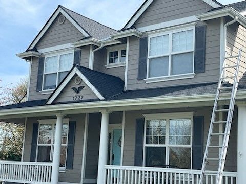A large house with a ladder on the front porch.