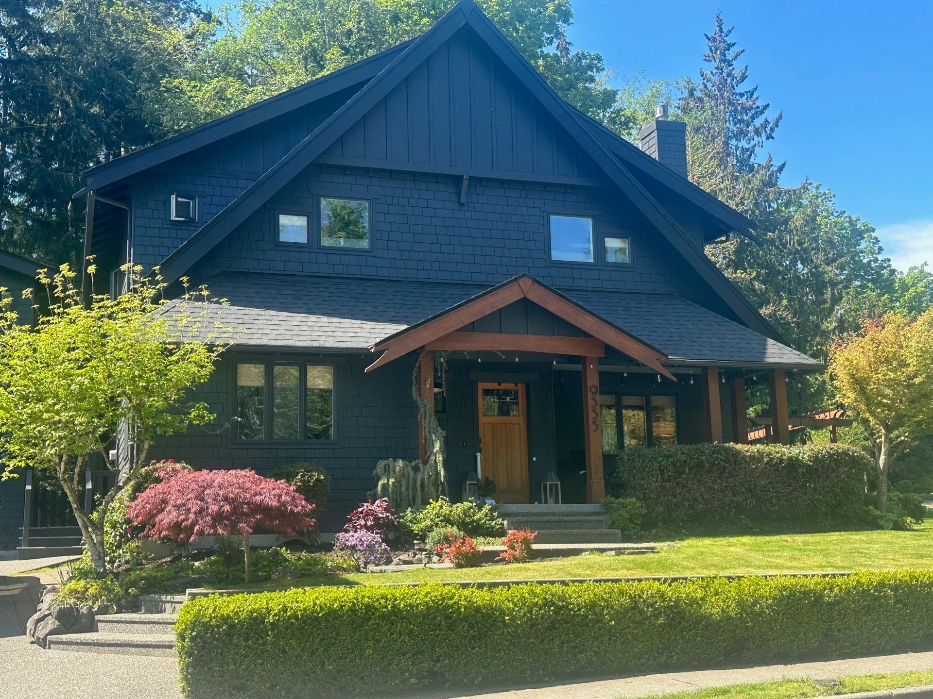 A large black house with a porch and a roof