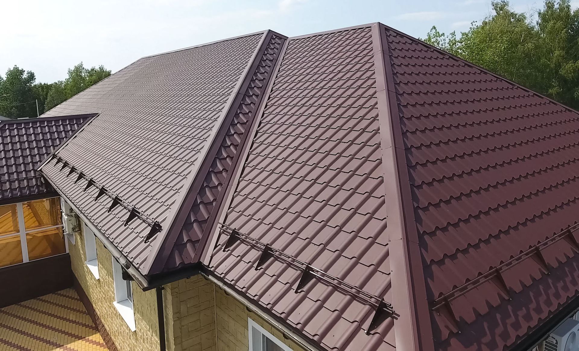 An aerial view of a house with a brown metal tiled roof.