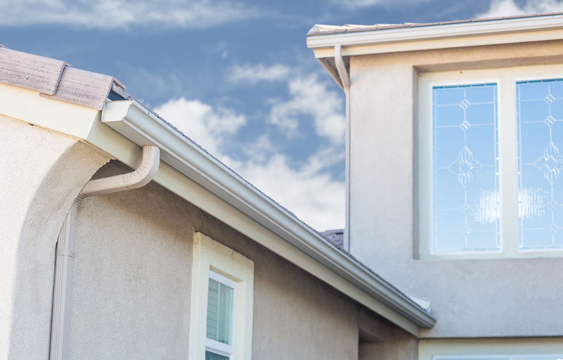A house with a gutter on the side of it and a window.