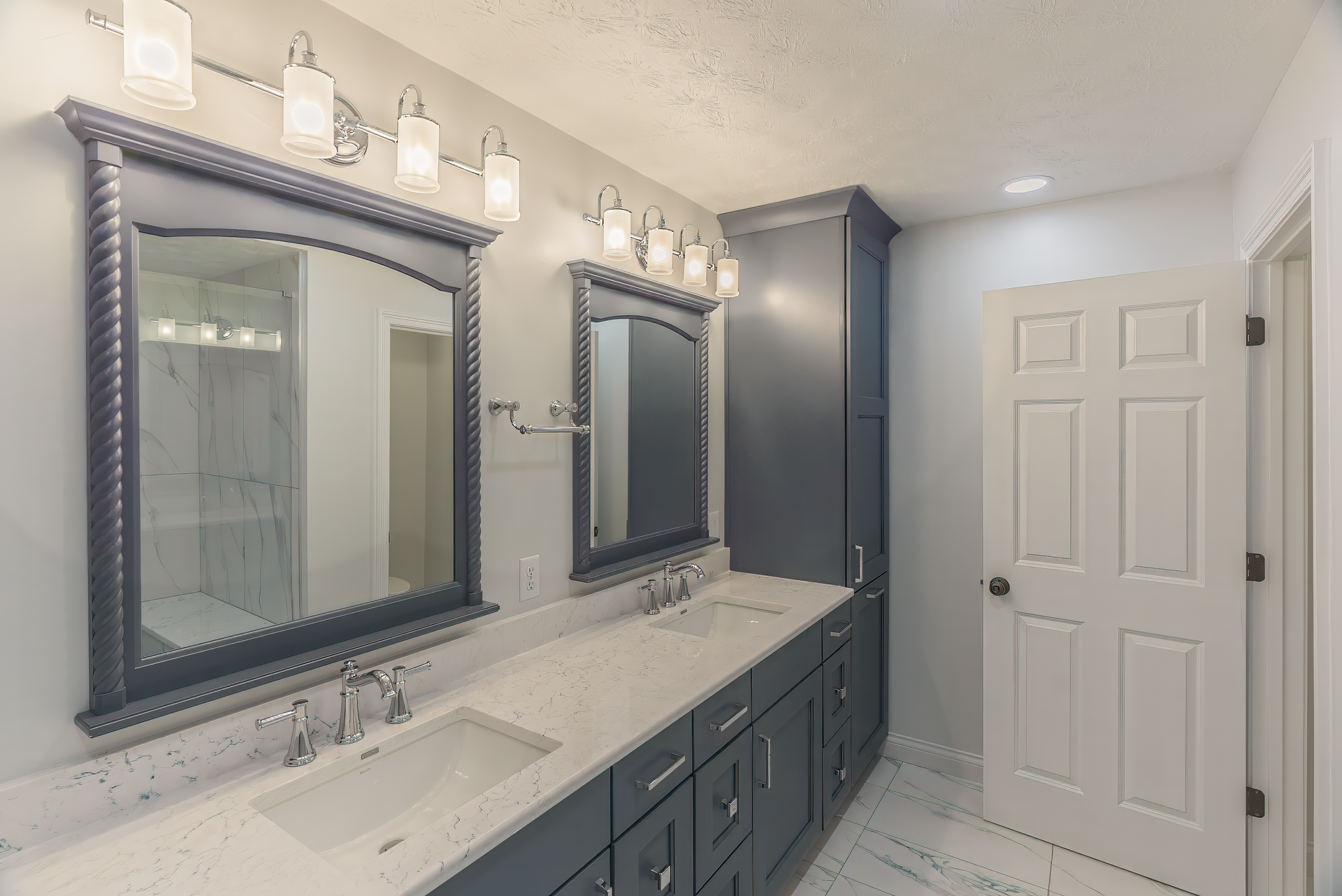 Gray and white bathroom with double vanity, mirrors, and storage cabinet.