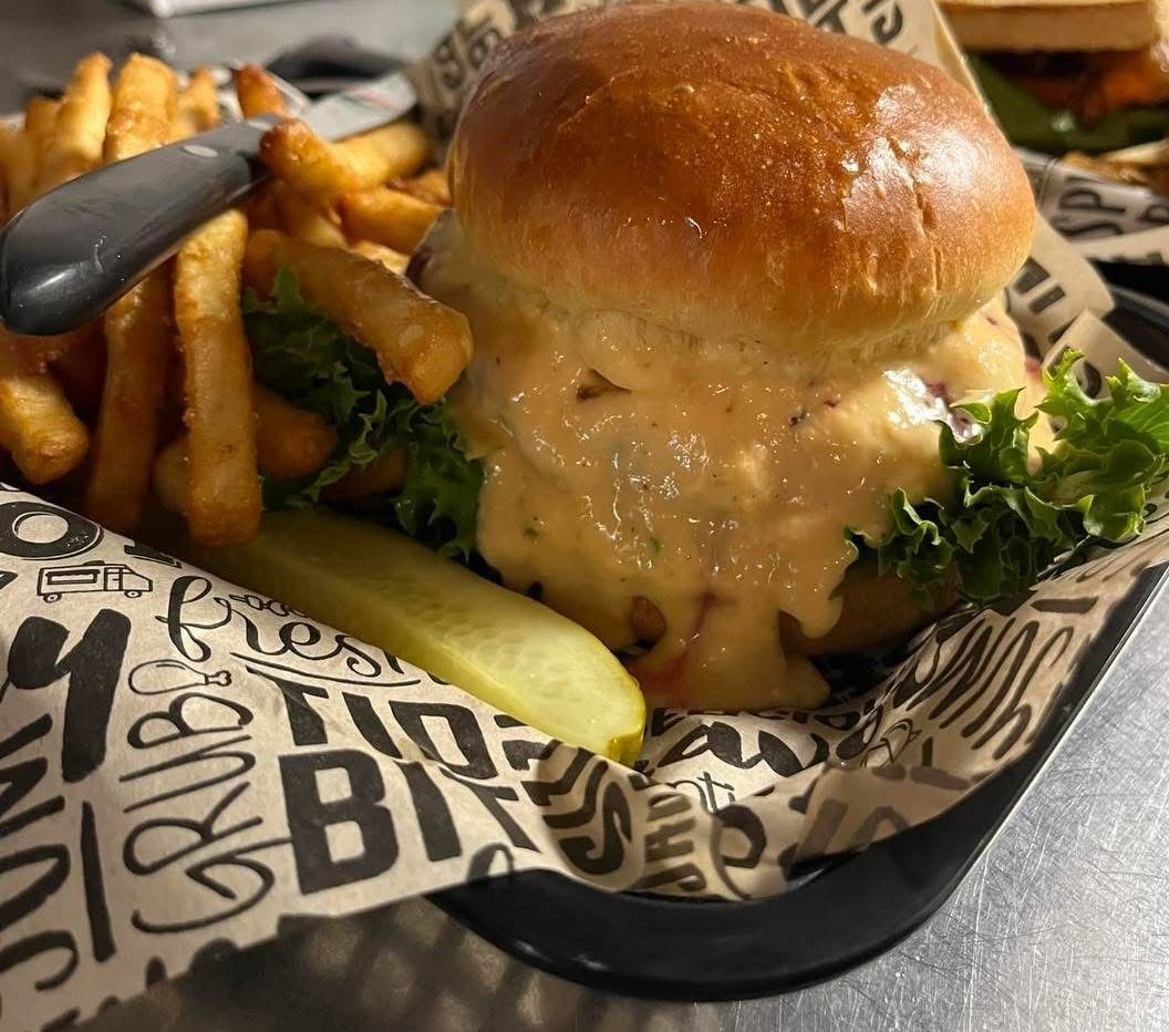 A close up of a sandwich and french fries on a table.